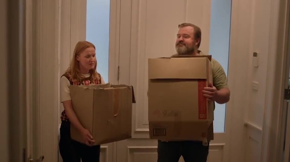 A couple carrying boxes into their new home